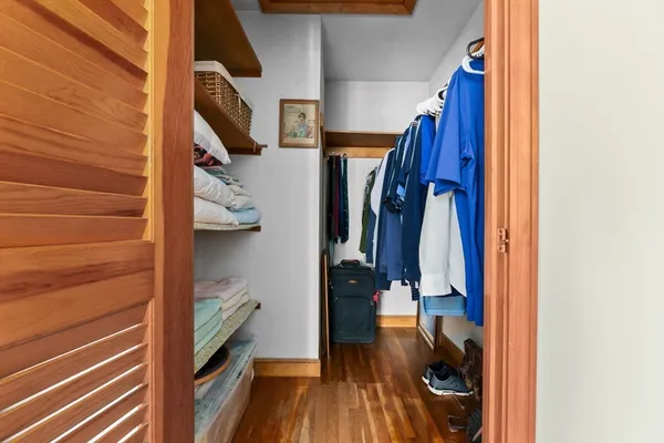 a view of walk in closet with clothes and shoes