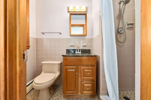 a bathroom with a toilet sink vanity and shower