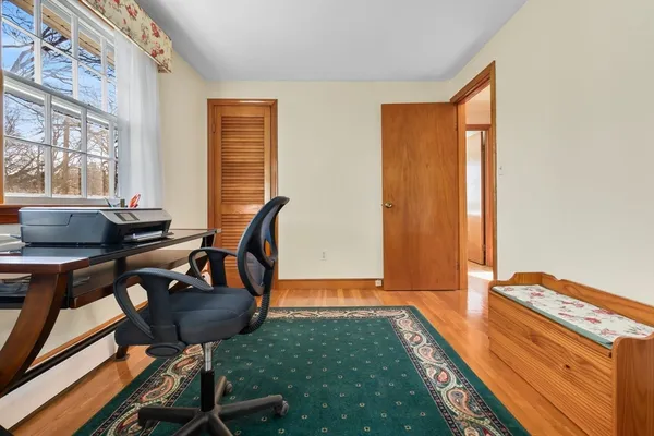 a view of a workspace with furniture and a window