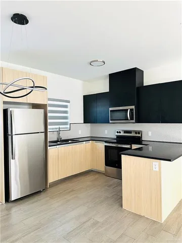 a kitchen with stainless steel appliances a refrigerator a stove a microwave and white cabinets