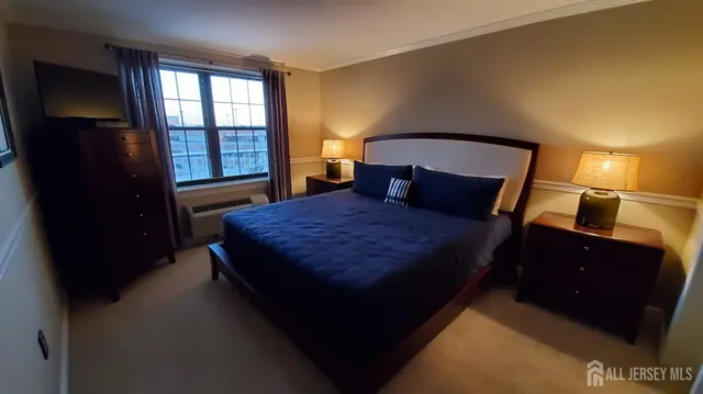 a bedroom with a bed and a lamp on dresser