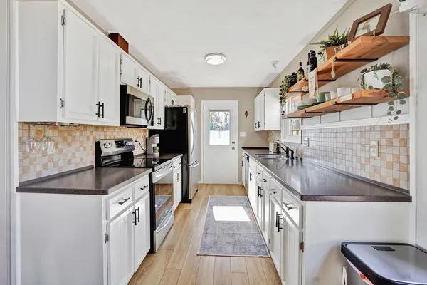 a kitchen with stainless steel appliances granite countertop a stove a sink and a microwave