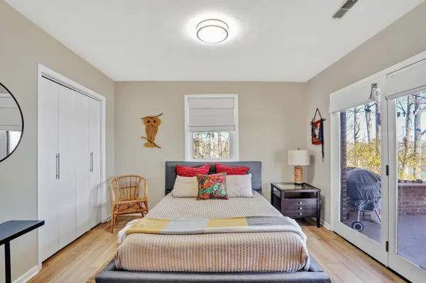 a bedroom with a bed and large windows