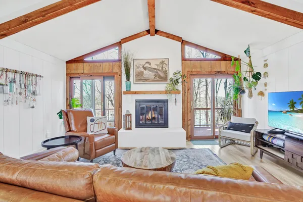 a living room with furniture a fireplace and a large window