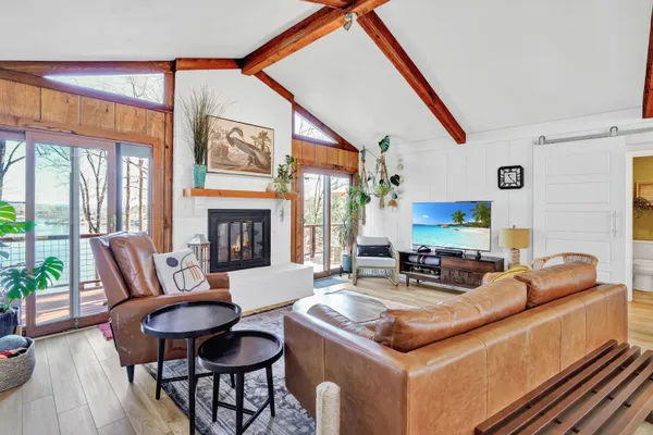 a living room with furniture a fireplace and a floor to ceiling window