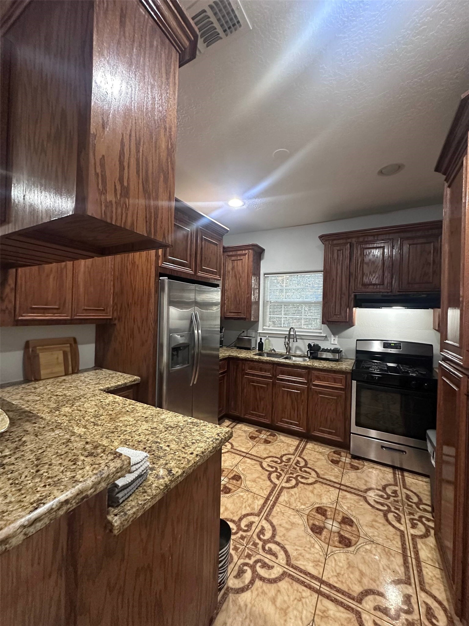 15 Stiles Street Houston, TX 77011 - Photo 21 of 33 a kitchen with granite countertop stainless steel appliances and wooden cabinets