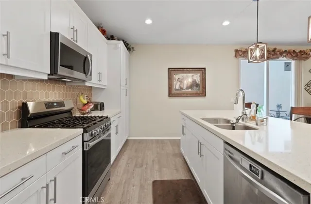 a kitchen with stainless steel appliances a sink stove and microwave