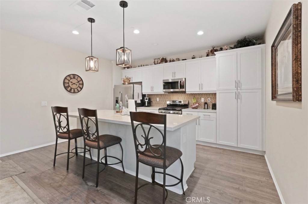 2248 Ridge Court Perris, CA 92571 - Photo 14 of 48 a kitchen with kitchen island white cabinets and white appliances