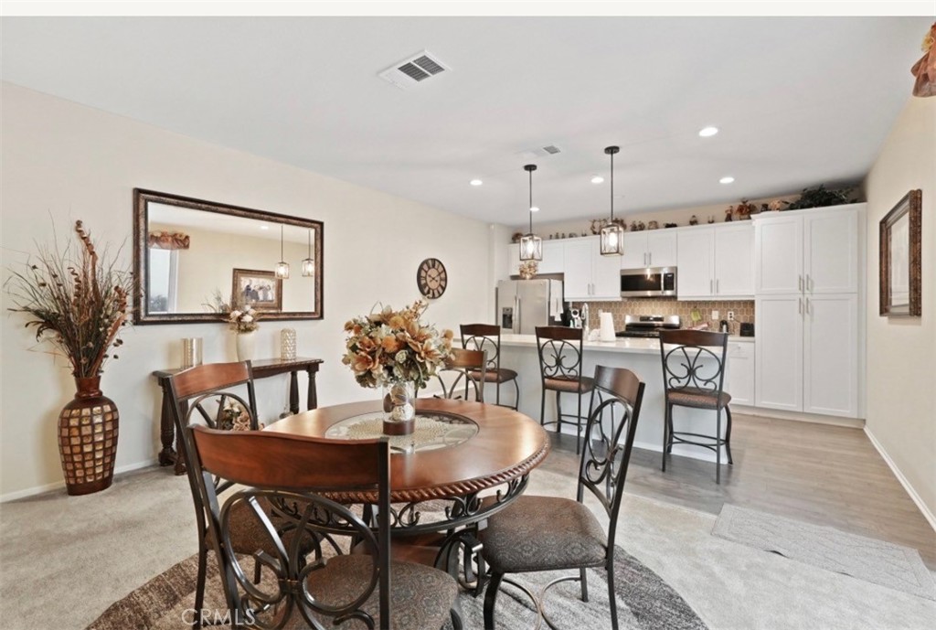 2248 Ridge Court Perris, CA 92571 - Photo 17 of 48 a view of a dining room with furniture and a potted plant