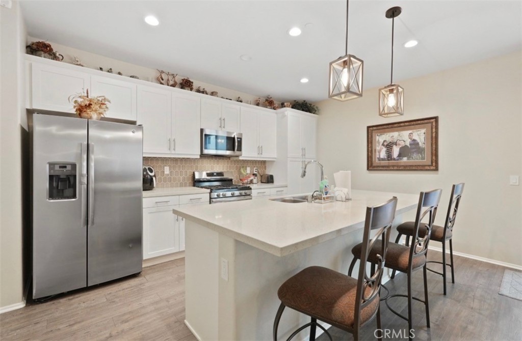 2248 Ridge Court Perris, CA 92571 - Photo 2 of 48 a kitchen with stainless steel appliances a refrigerator a stove a sink a dining table and chairs