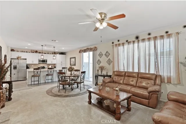 a living room with furniture kitchen view and a chandelier