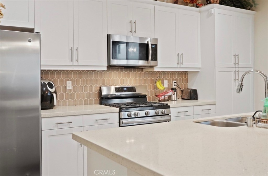 2248 Ridge Court Perris, CA 92571 - Photo 5 of 48 a kitchen with stainless steel appliances granite countertop a sink a stove and a refrigerator