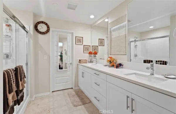 a bathroom with a double vanity sink mirror and shower