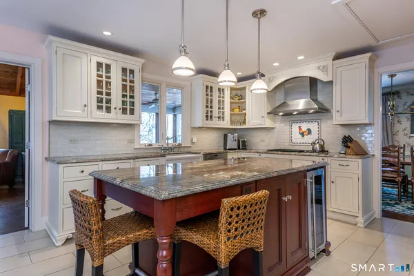 a kitchen with stainless steel appliances granite countertop a stove a kitchen island a dining table and chairs