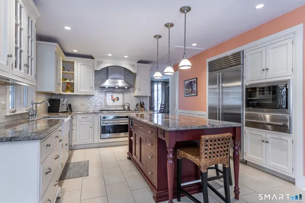 a kitchen with stainless steel appliances granite countertop a stove a sink and a refrigerator