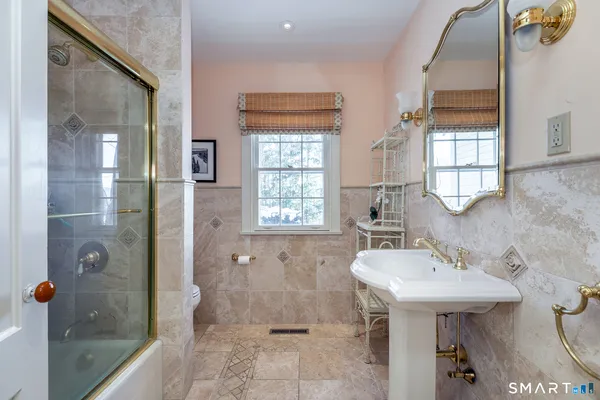 a bathroom with a sink a toilet and shower