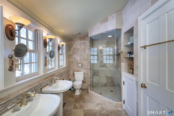 a bathroom with a granite countertop sink a toilet and shower
