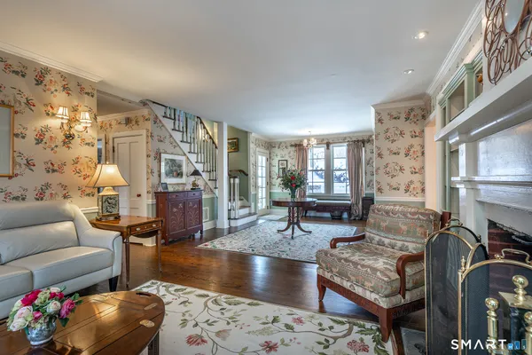 a living room with fireplace furniture and a rug