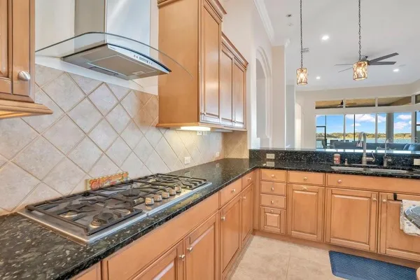 a kitchen with stainless steel appliances granite countertop a sink stove and cabinets