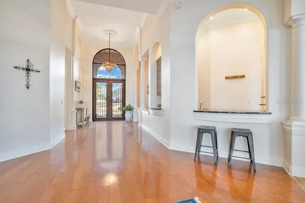 a dining room with furniture a chandelier and wooden floor