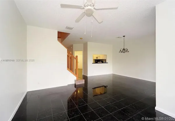 a view of a livingroom with wooden floor and a ceiling fan