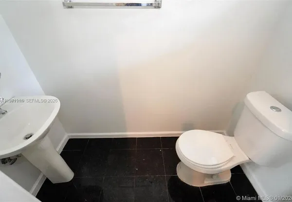 a white toilet sitting next to a white sink