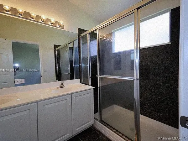 a bathroom with a shower sink and mirror
