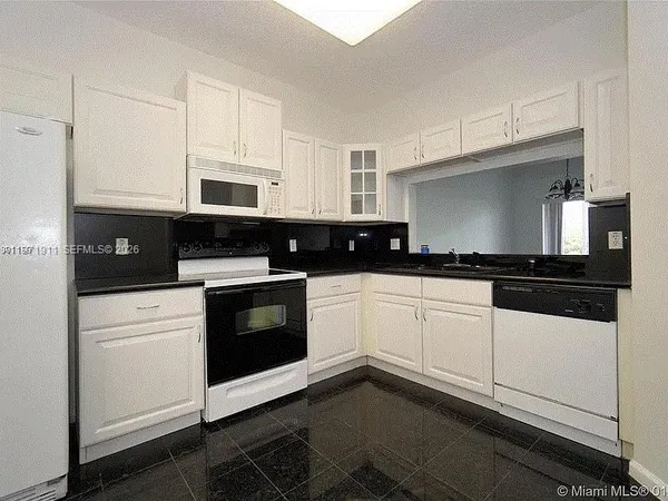a kitchen with granite countertop white cabinets and black appliances