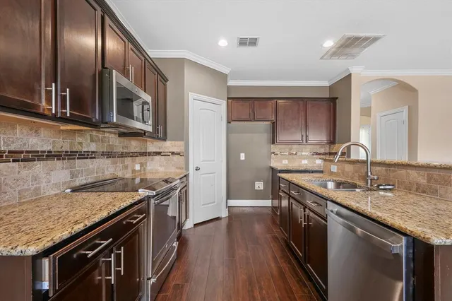 a kitchen with stainless steel appliances granite countertop a sink stove and cabinets