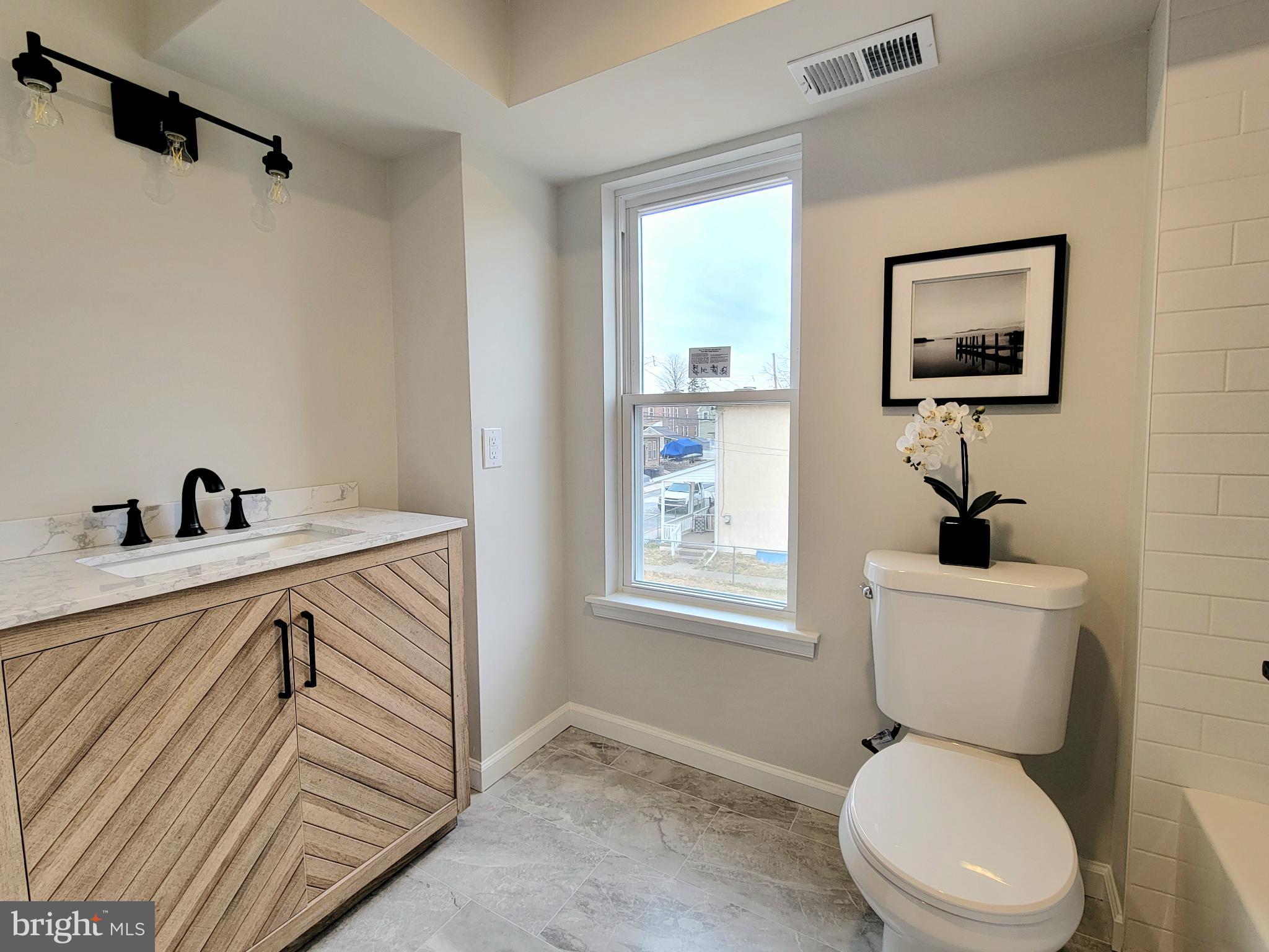 17 West 2nd Street Marcus Hook, PA 19061 - Photo 17 of 38 a bathroom with a sink a toilet and a mirror
