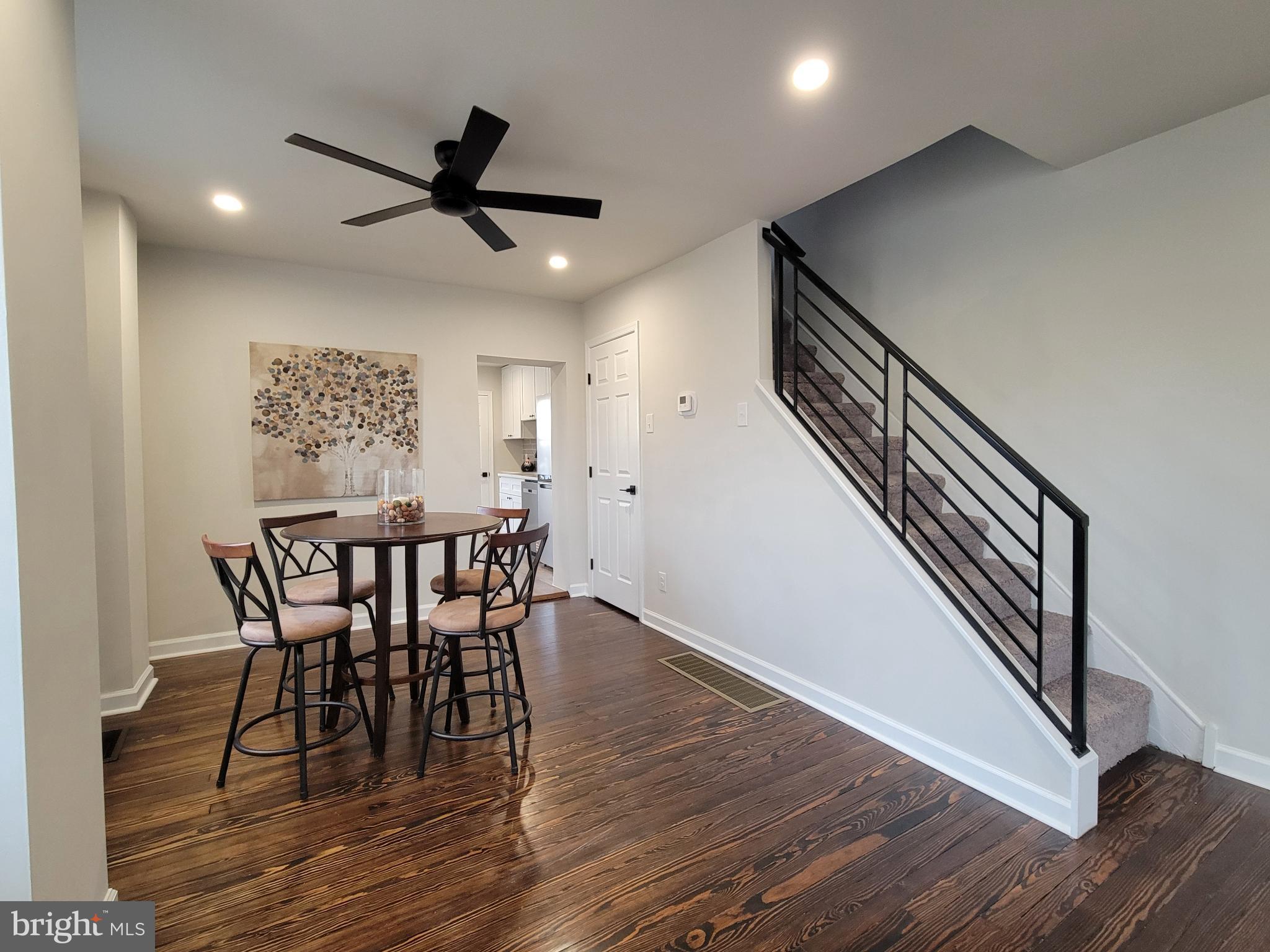 17 West 2nd Street Marcus Hook, PA 19061 - Photo 7 of 38 a view of a dining room with wooden floor a ceiling fan and staircase