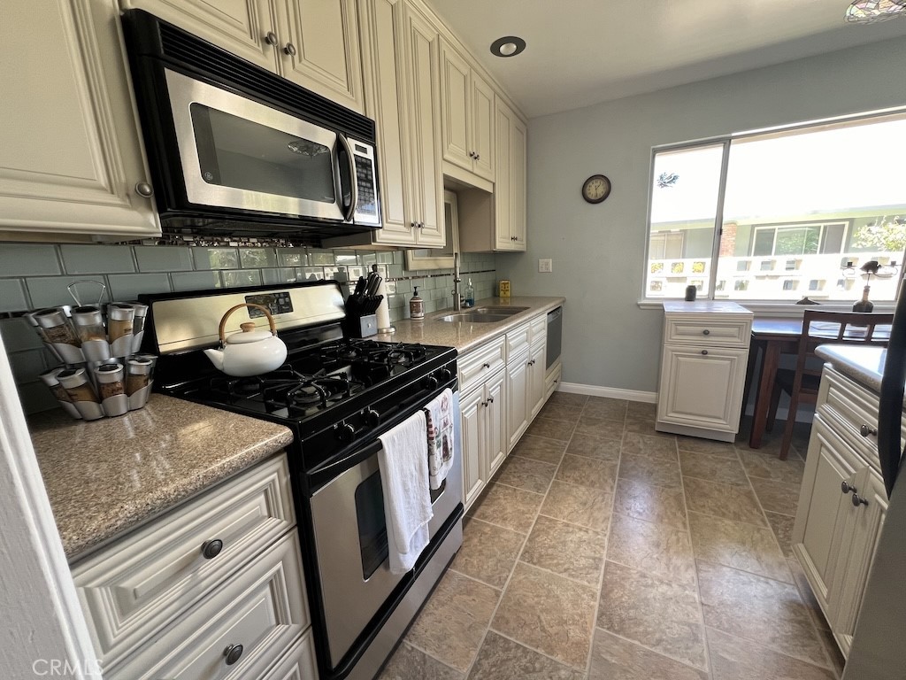 152 East Bowling Green Port Hueneme, CA 93041 - Photo 4 of 33 a kitchen with stainless steel appliances granite countertop a stove a sink and a microwave