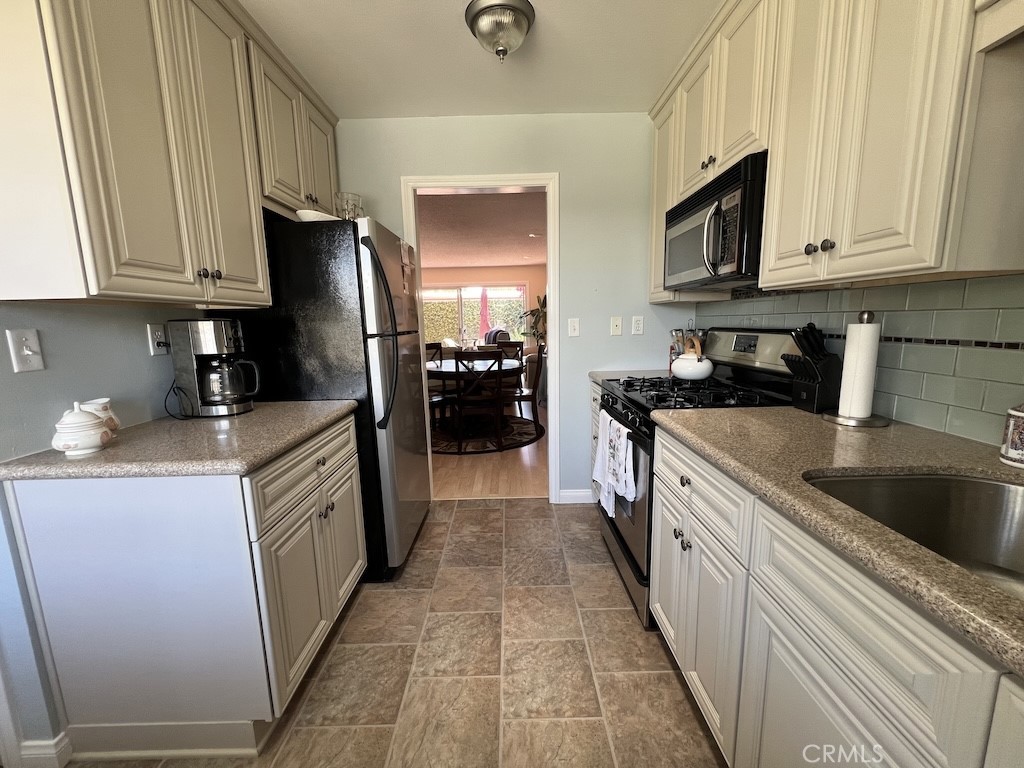 152 East Bowling Green Port Hueneme, CA 93041 - Photo 7 of 33 a kitchen with stainless steel appliances granite countertop a refrigerator a sink a stove and microwave