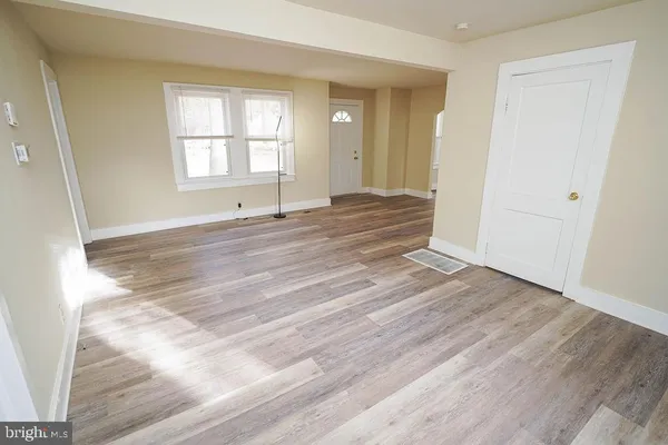 a view of empty room with window and wooden floor