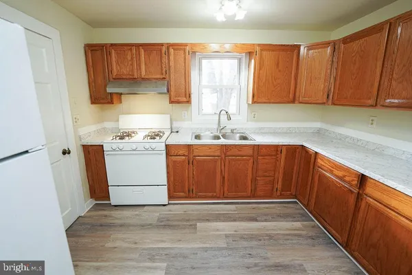 a view of a kitchen with wooden floor and cabinets