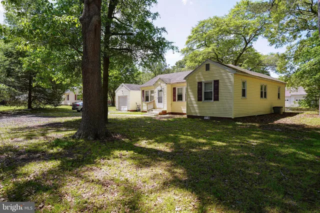 a white house that has tree in front of it