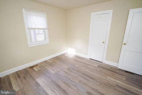 a view of a room with wooden floor and a ceiling fan
