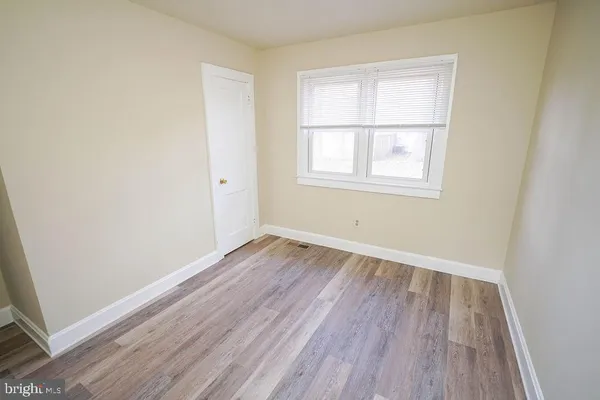 an entryway with wooden floor and cabinet