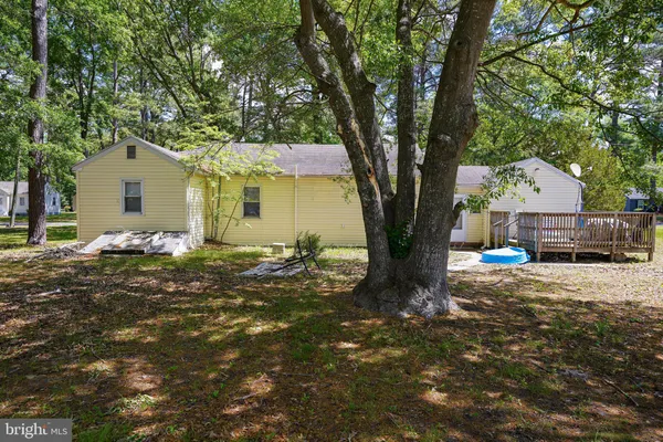 a front view of a house with a tree