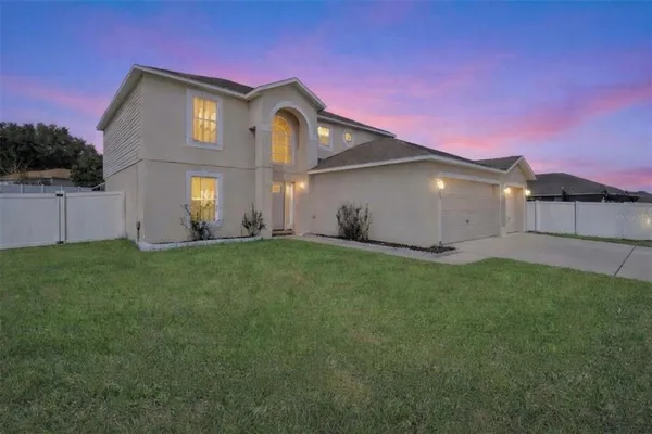 a front view of a house with a garden and yard