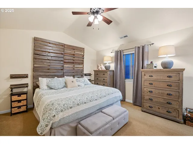 a bedroom with a bed a dresser and a chandelier