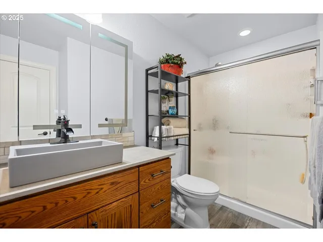 a bathroom with a sink a toilet and shower