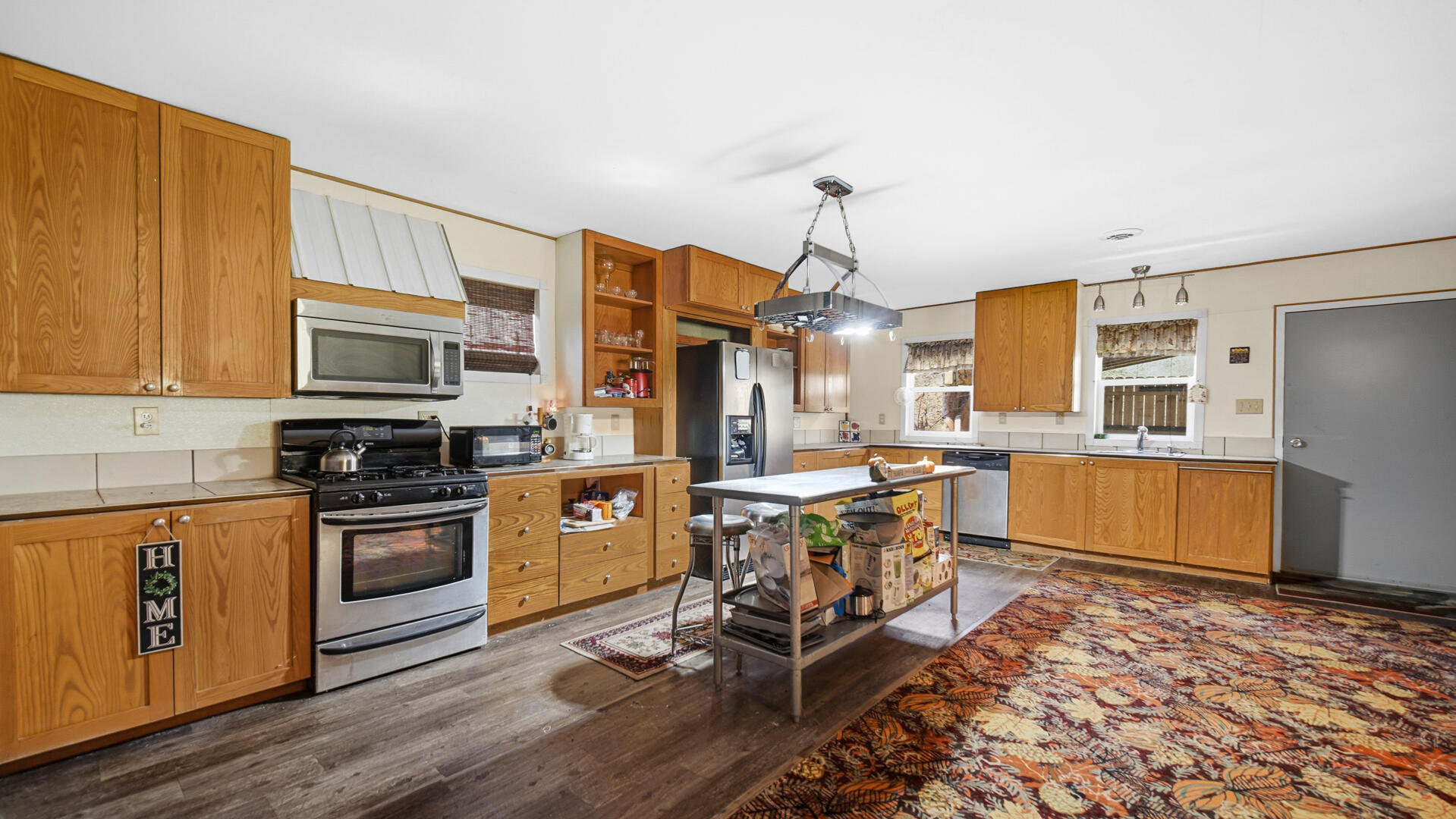 5505 West Schultz Road La Porte, IN 46350 - Photo 22 of 39 a kitchen with stainless steel appliances granite countertop a stove top oven a sink dishwasher a dining table and chairs with wooden floor