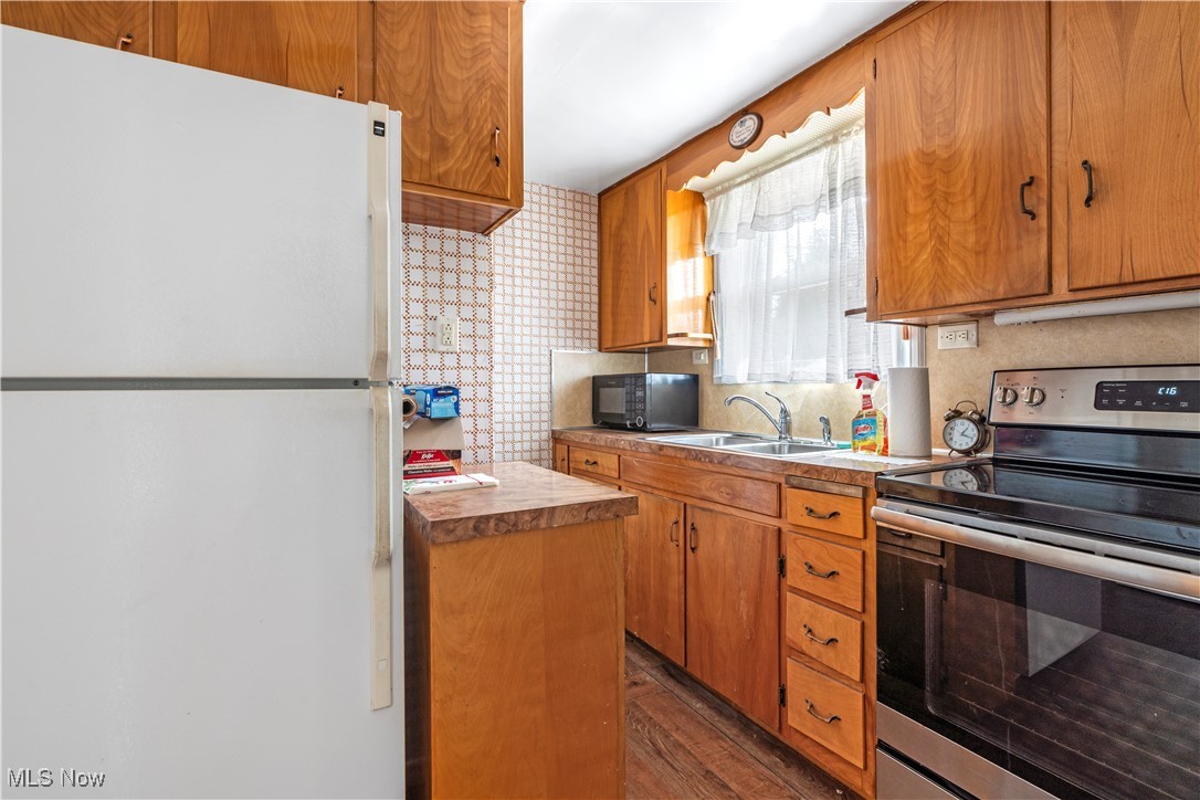 61 Ledge Road Northfield, OH 44067 - Photo 7 of 23 Kitchen with stainless steel electric stove, tasteful backsplash, dark wood-type flooring, sink, and white refrigerator