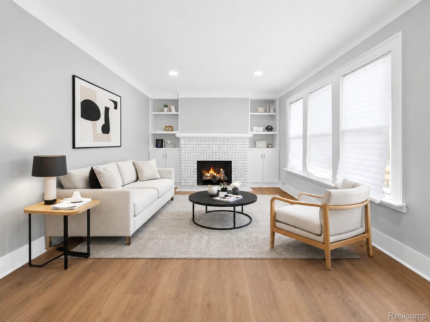 9175 Devonshire Road Detroit, MI 48224 - Photo 3 of 23 Living area featuring wood-finish flooring, a white brick fireplace, built-in shelving, recessed lighting, and multiple windows