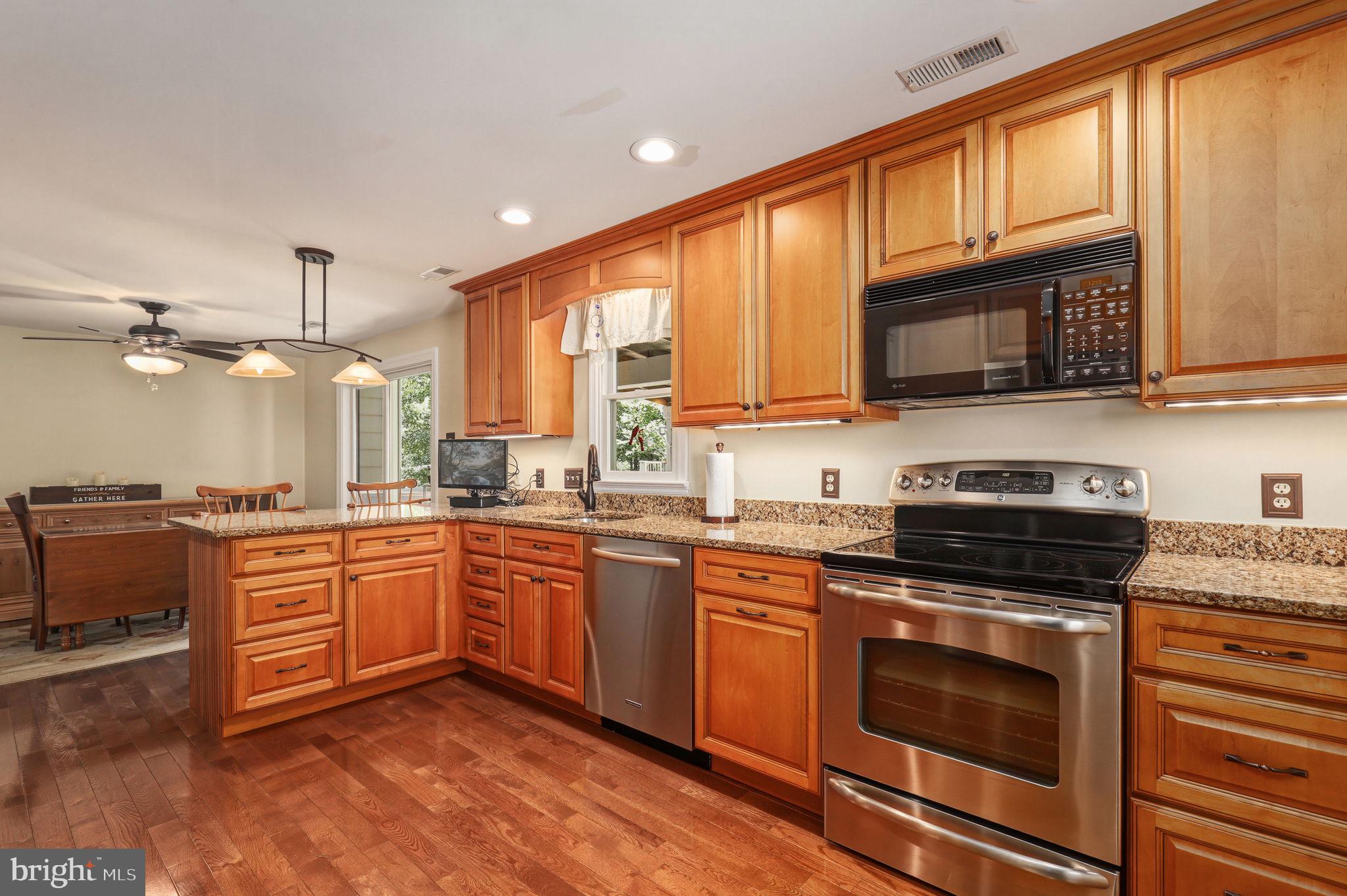 6336 Boyers Mill Road New Market, MD 21774 - Photo 10 of 49 a kitchen with stainless steel appliances granite countertop wooden cabinets stove top oven and sink