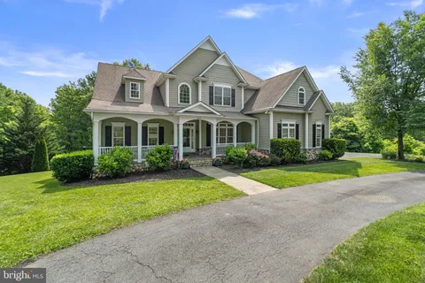 a front view of a house with a yard and potted plants