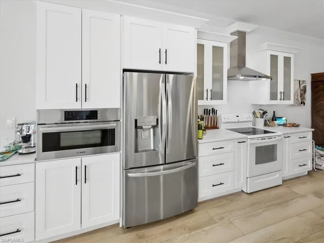 a kitchen with granite countertop a refrigerator stove and microwave