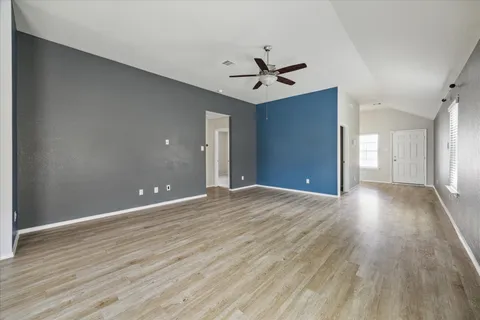 a view of a big room with wooden floor and windows in a room