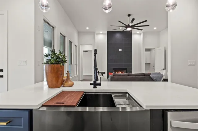 a kitchen view of a kitchen island sink stove and refrigerator